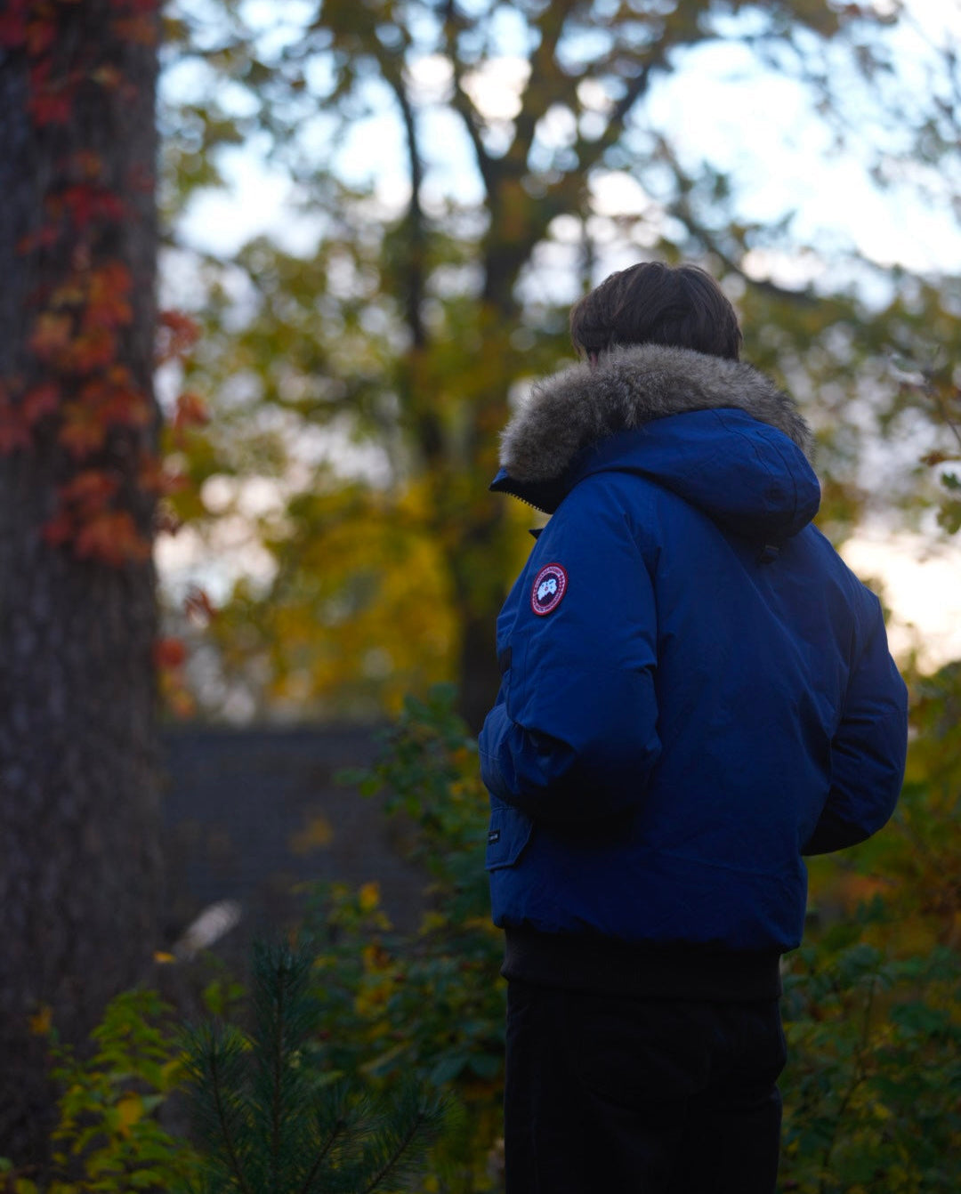Man wearing blue Canada Goose Chilliwack bomber in a a light setting