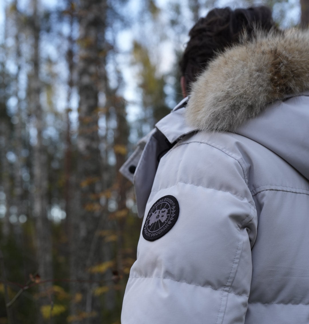 Man wearing a Canada Goose wyndham parka with a fur-lined hood. 